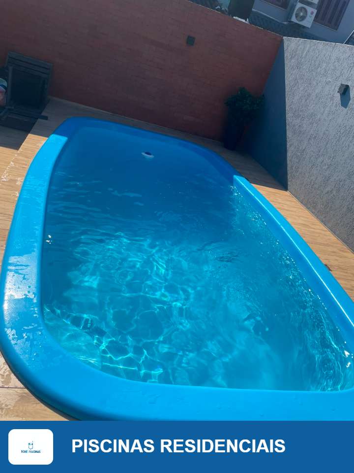 Piscina residencial de fibra azul com deck de madeira